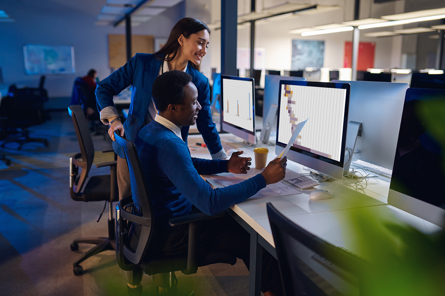 Two happy managers working in night office